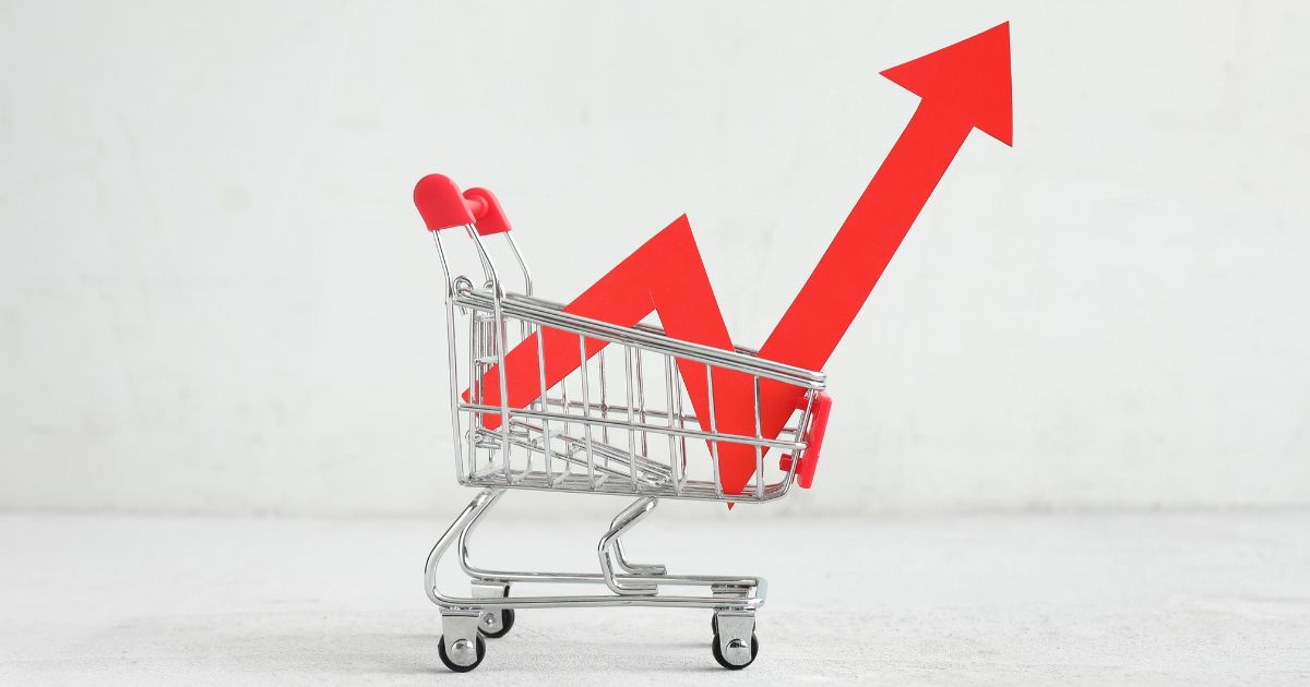 Carrito de compras con gráfico de crecimiento que representa cómo escalar ventas B2B y aumentar ingresos